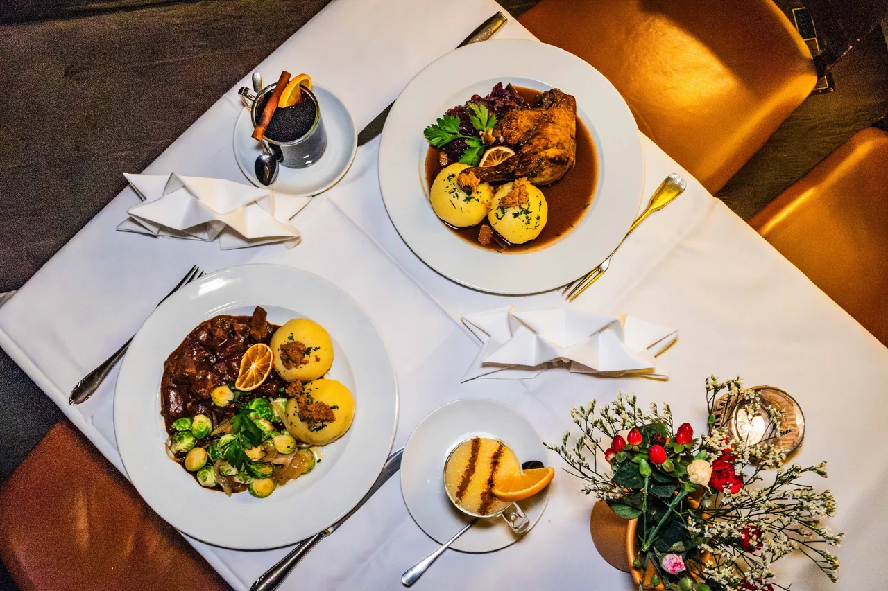Gedeckter Tisch im Restaurant Nüsslein Erfurt mit geschmorter Keule, Gulasch, Thüringer Klößen und Eierpunsch