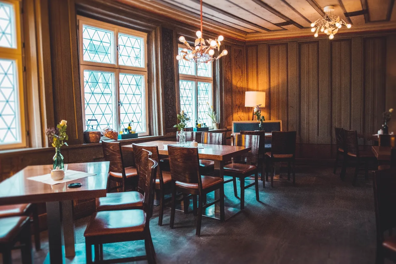 Historische Bohlenstube im Café Nüsslein Erfurt mit Holzvertäfelung, Bleiglasfenstern und gedeckten Tischen